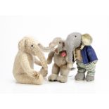 Two artist made elephants, a grey plush jointed elephant with checked trousers and blue jacket --11