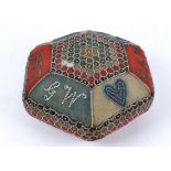 A large Edwardian hexagonal layette pin cushion, with a central beaded motif, the external border