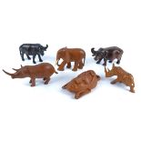 A collection of carved African animals, including two rhinos, two buffalos and a Masi head