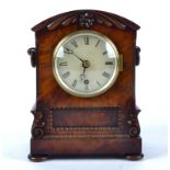 A William IV mahogany bracket clock, domed top with carved motifs standing on bun feet, white dial