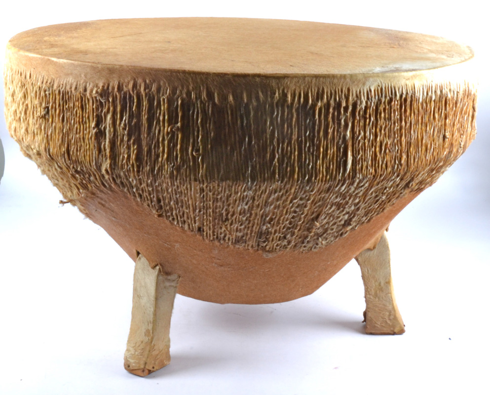 A large hide African drum on three legs, no obvious tears. Diameter 76cm.