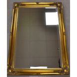 Two modern swept gilt framed wall mirrors, the larger having bevelled plate, 107cm x 76cm and 64cm x