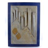 A decorative wall panel 'Sky City', carved and painted piece of wood mounted on a blue board,