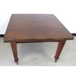 An Edwardian mahogany wind out dining table, raised on reeded tapering supports with one leaf and