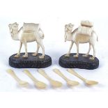 A pair of early 20th Century carved ivory camels, on wooden bases, height 14.5cm, together with a