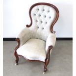 A Victorian mahogany spoon back arm chair, with carved scrolled arms finishing to cabriole front
