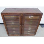 A late 19th Century stained pine specimen cabinet, double glazed doors enclosing two banks of twenty