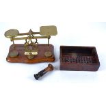 A set of early 20th Century brass postal scales, set on a wooden base with weights, together with