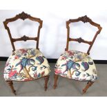 A pair of Victorian walnut side chairs, carved backs and rails, raised on front fluted supports,