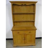 A contemporary waxed pine dresser, top section with moulded cornice, closed panelled back with two