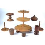 An assortment of turned treen, to include a three tier stand, raised on three bun feet, height 37cm,