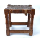 An Early Robert Mouseman (1876 – 1955) Stool, a carved oak rectangular jointed seat with leather