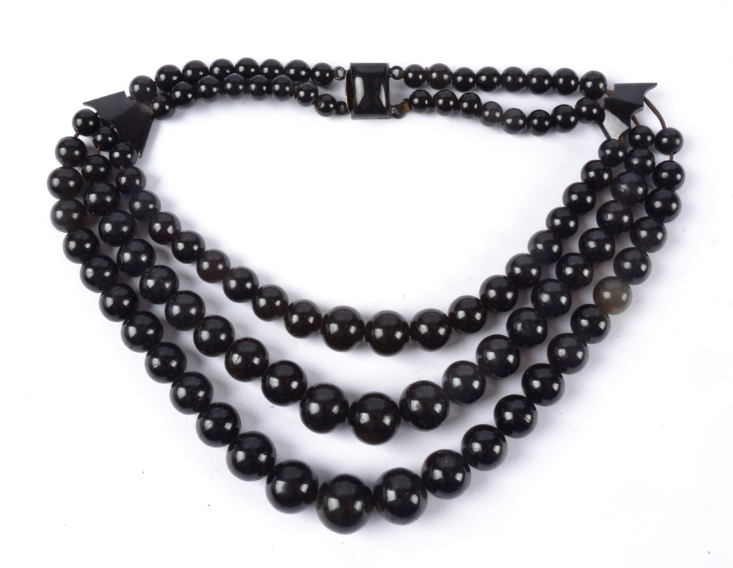 A jet necklace with spherical beads, on three strings, length 25cm