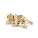 A Meiji period ivory netsuke, carved as a reclining man, AF, length 4.5cm