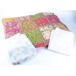 A quantity of vintage textiles, blankets and duvets with floral decoration, assorted colours and