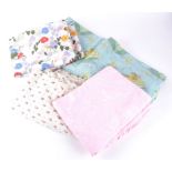 A quantity of vintage textiles, duvet covers, blankets and pillowcases in printed floral decoration,