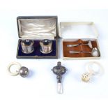 A boxed hallmarked silver baby's spoon and push, together with three Victorian and later rattles,