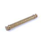 A Victorian chased brass needle or scroll case, cylindrical form with screw caps to either end,