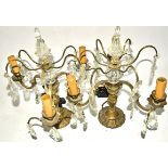 A pair of gilt metal and prism glass table lights, of three branched form, with faceted glass drops,
