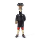 A comical early 20th Century figure, modelled and painted as a gentleman in hat, coat and
