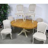 A Laura Ashley dining table and chairs, with a pine circular drawer leaf action top with pop up