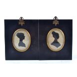 A companion pair of oval silhouette portrait miniatures of Georgian ladies, in ebonised frames,