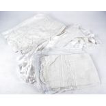 A quantity of 20th Century linen and cotton, christening gowns and tablecloths, some with