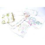 A collection of embroidered cotton and linen, including placemats, tablecloths, napkins and more,