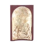 An 18th Century German ivory relief carving of the Pieta, the Virgin kneeling on the ground with the
