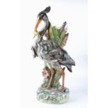 A Continental pottery stick or umbrella stand c1900 taking the form of a heron eating a fish, height