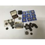 A box containing a collection of coinage and commemorative coin medals, including British and
