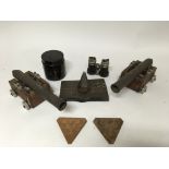 A group of miniature cannons, trench art, cased opera binoculars and cannonballs.