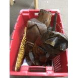 A plastic crate containing a collection of carved tribal masks.