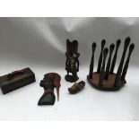 A box containing a collection of treen items, also including two tribal sculptures, cups, and more.