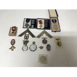 A group of Masonic medals and badges including silver gilt. Also included is two pocket watches, one