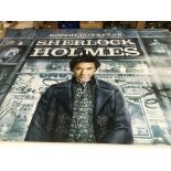 A collection of film posters including a large vinyl poster for 'Sherlock Holmes' plus smaller