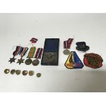 A group of military items to include First World War medals, unmarked, patches, a German WW2 badge