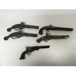 A group of replica pistols including 4 antique flintlocks, and a revolver.