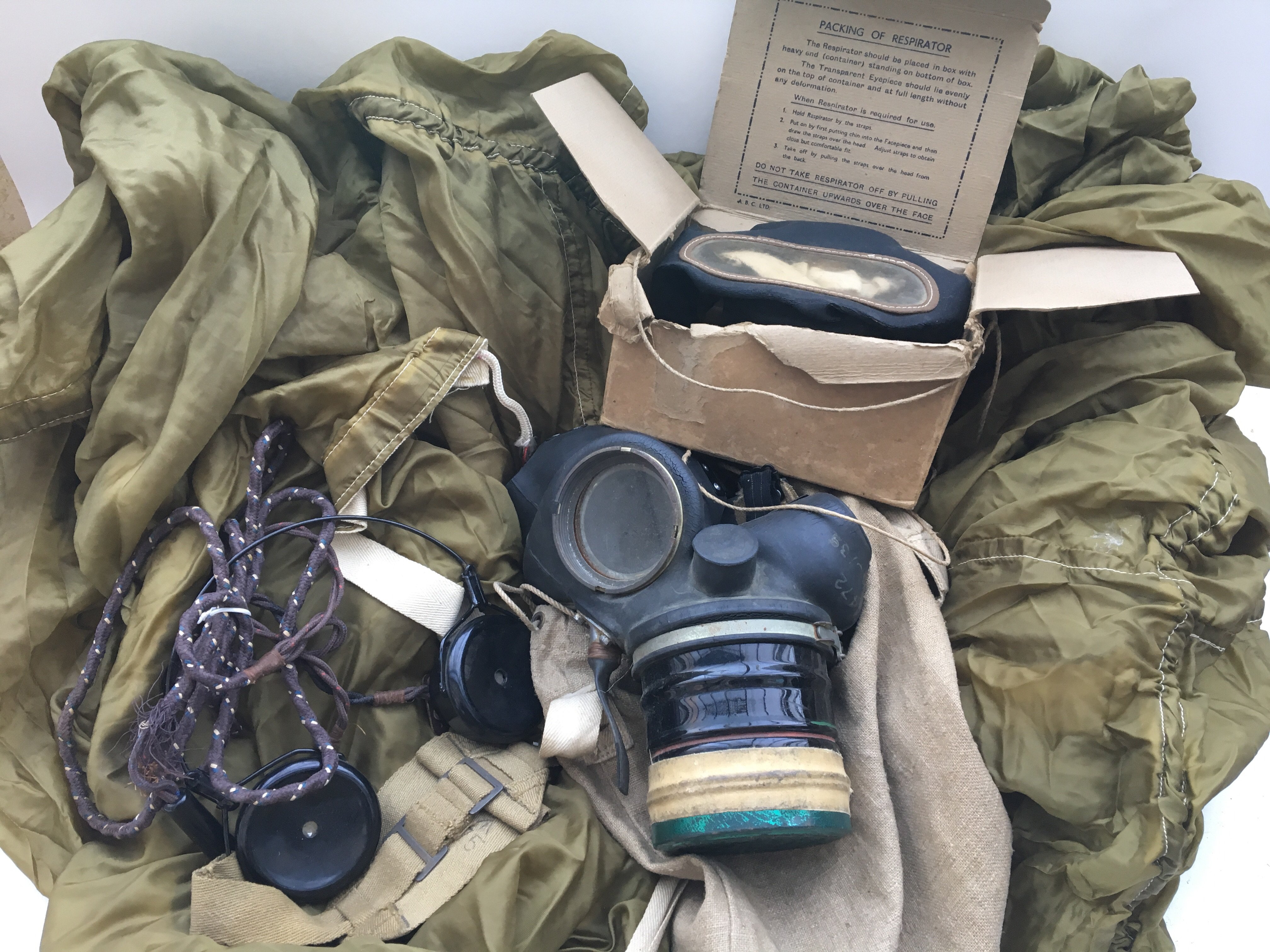 Items from WW2 including a parachute, gas mask in cloth bag and respirator in original box
