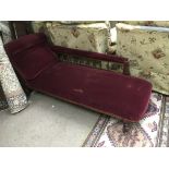 A Victorian chaise longue in dark red upholstery.
