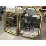 A gilt framed wall mirror with a bevelled edge pla