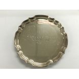 A small silver salver with shaped edge and inscrib