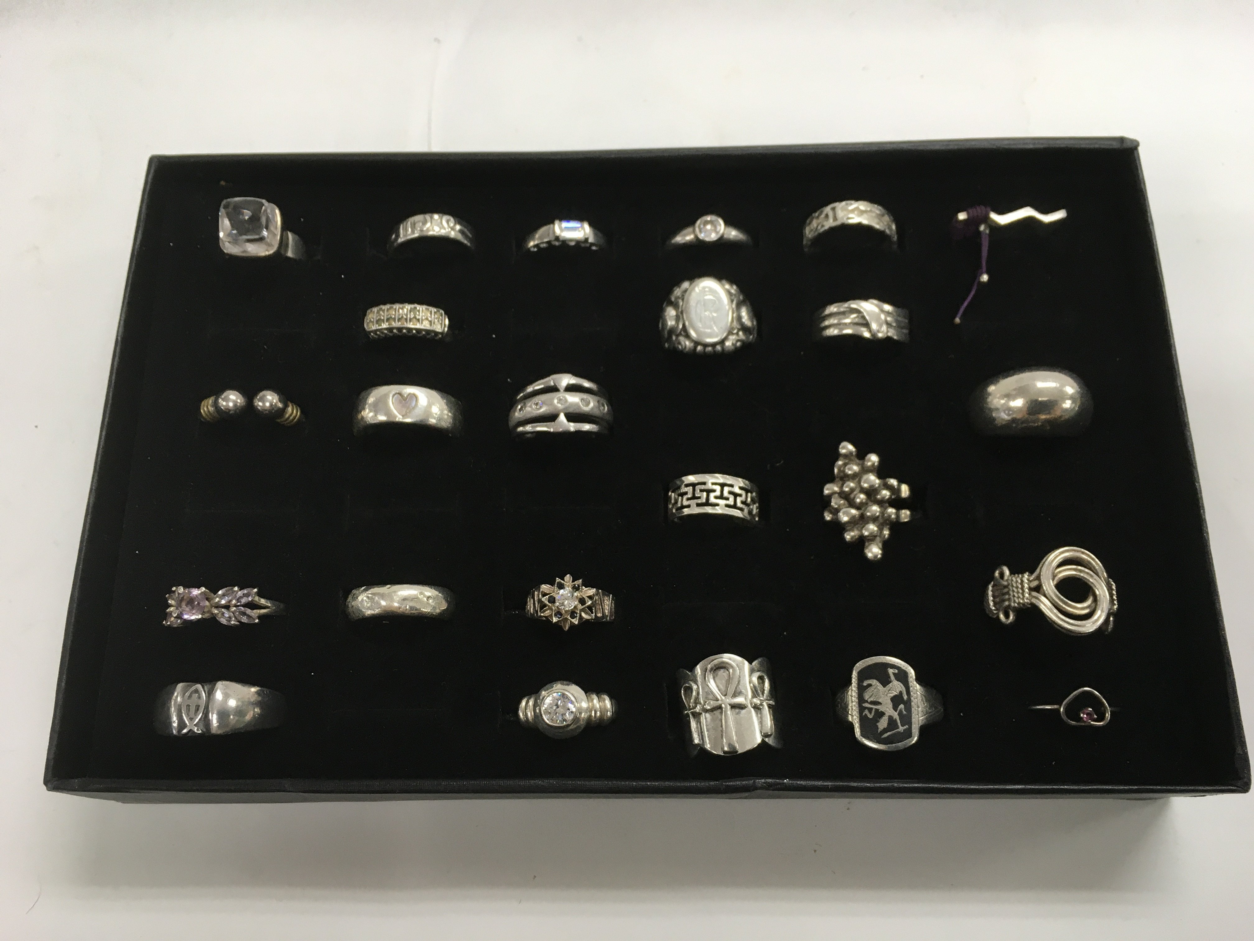 A collection of 24 silver rings, various styles an