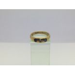 An 18ct gold ring set with a central diamond and t