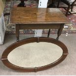 An oak occasional table and oval wall mirror