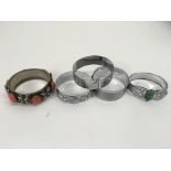 Four chrome bangles and one other relief decorated