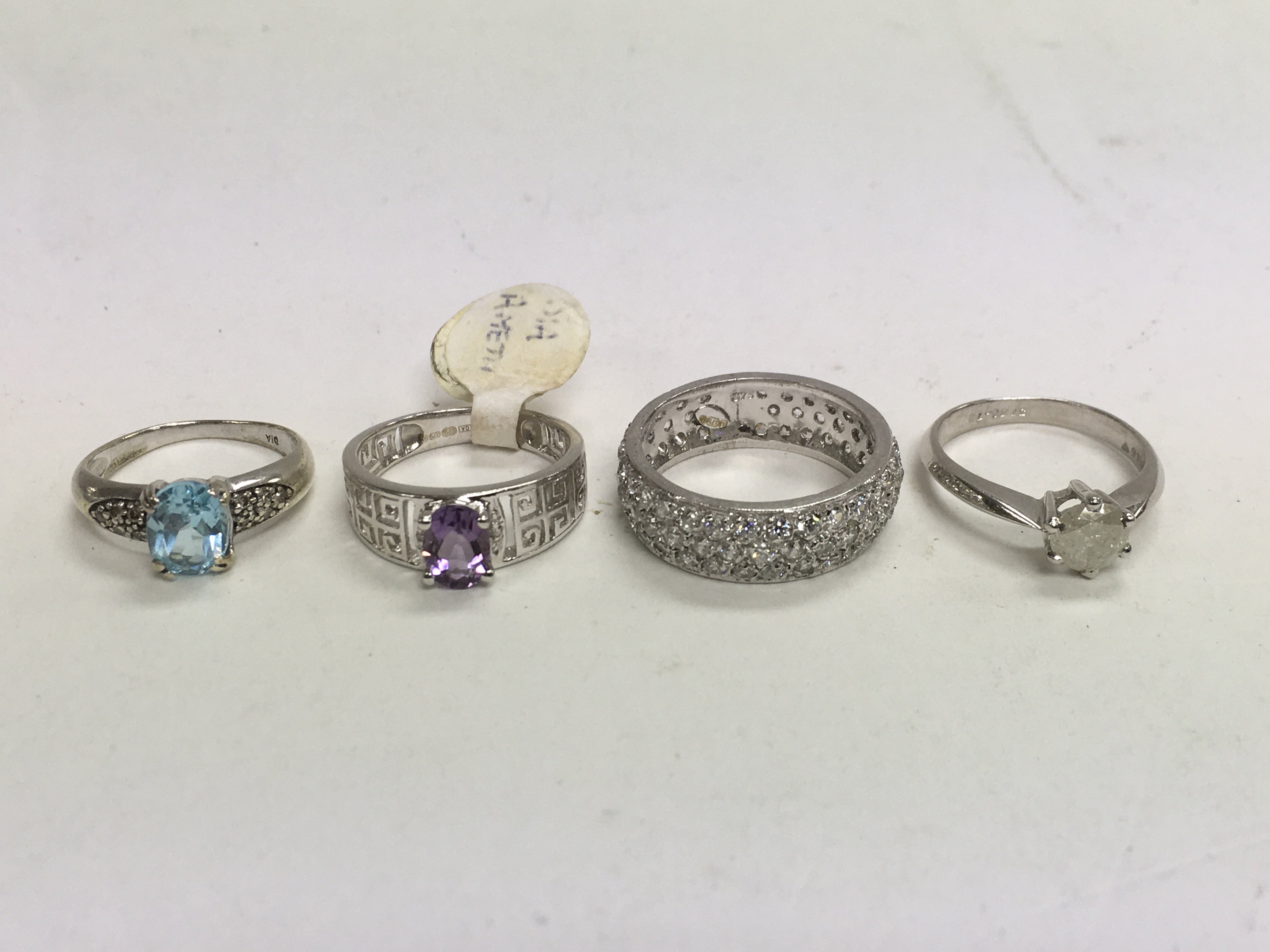 Four white gold rings set with stones, approx 12.4