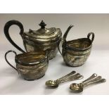 A matching three piece silver tea service and six