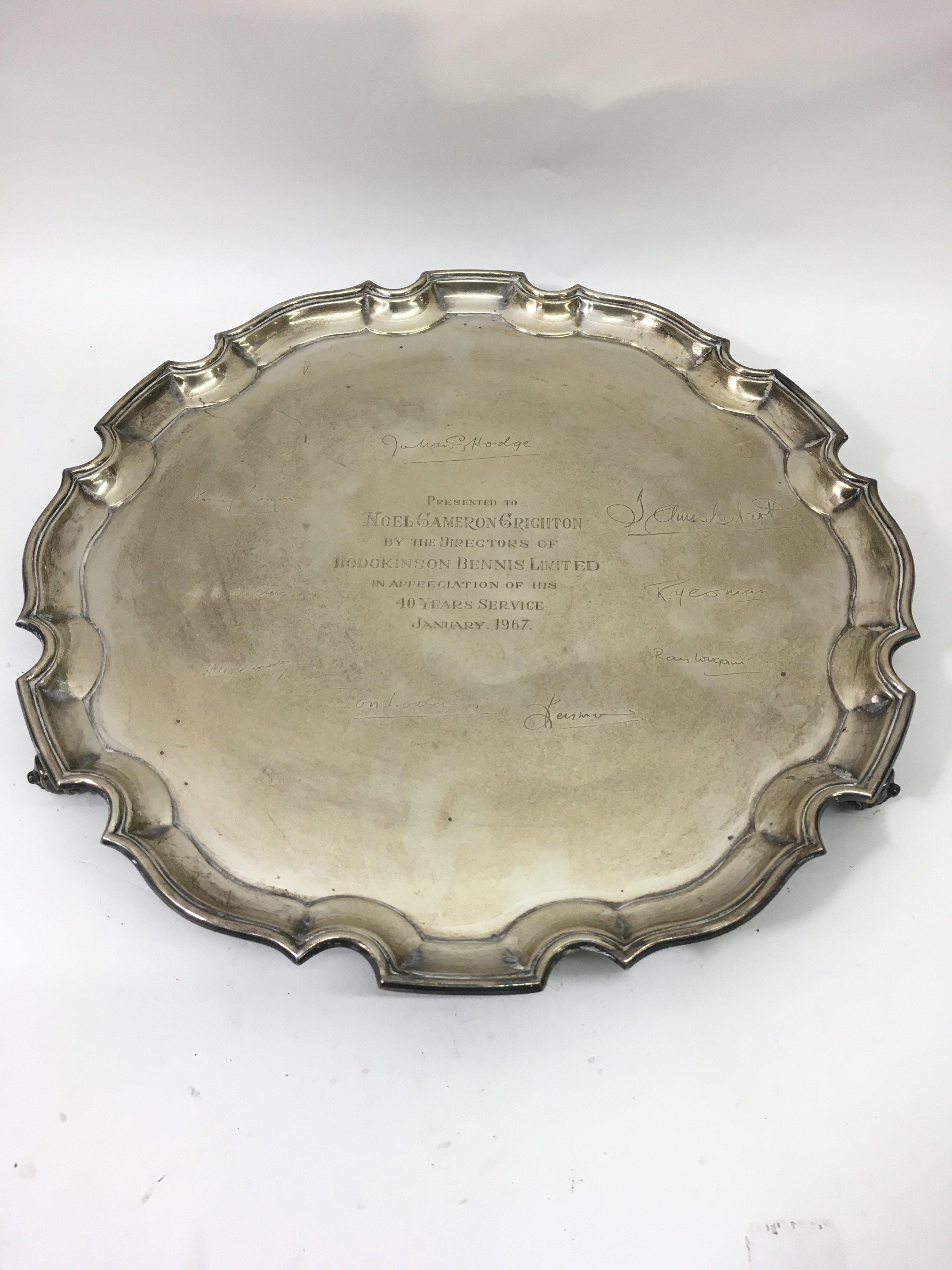 A large silver tray with pie crust edge having engraved presentation and signatures relating to