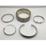 Five silver bangles.